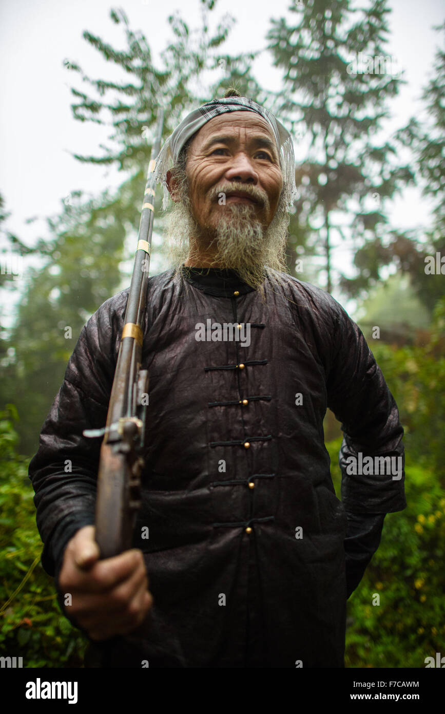Congjiang, a sud-ovest della Cina di Guizhou. 28 Nov, 2015. Un abitante locale mantiene la sua pistola per salutare i turisti al Basha villaggio di Miao gruppo etnico in Congjiang county, a sud-ovest della Cina di Guizhou, nov. 28, 2015. Il villaggio è risieduto dal popolo del Miao gruppo etnico che hanno mantenuto la loro unica le usanze e la cultura risalenti alle Dinastie Ming e Qing. Ogni maschio adulto di questo villaggio possiede un fucile da caccia in polvere, che ha valso il titolo di "l'ultimo banditi la tribù dei Miao gruppo etnico". © Liu Xu/Xinhua/Alamy Live News Foto Stock Congjiang, a sud-ovest della Cina di Guizhou. 28 Nov, 2015. Un abitante locale mantiene la sua pistola per salutare i turisti al Basha villaggio di Miao gruppo etnico in Congjiang county, a sud-ovest della Cina di Guizhou, nov. 28, 2015. Il villaggio è risieduto dal popolo del Miao gruppo etnico che hanno mantenuto la loro unica le usanze e la cultura risalenti alle Dinastie Ming e Qing. Ogni maschio adulto di questo villaggio possiede un fucile da caccia in polvere, che ha valso il titolo di "l'ultimo banditi la tribù dei Miao gruppo etnico". © Liu Xu/Xinhua/Alamy Live News Foto Stock