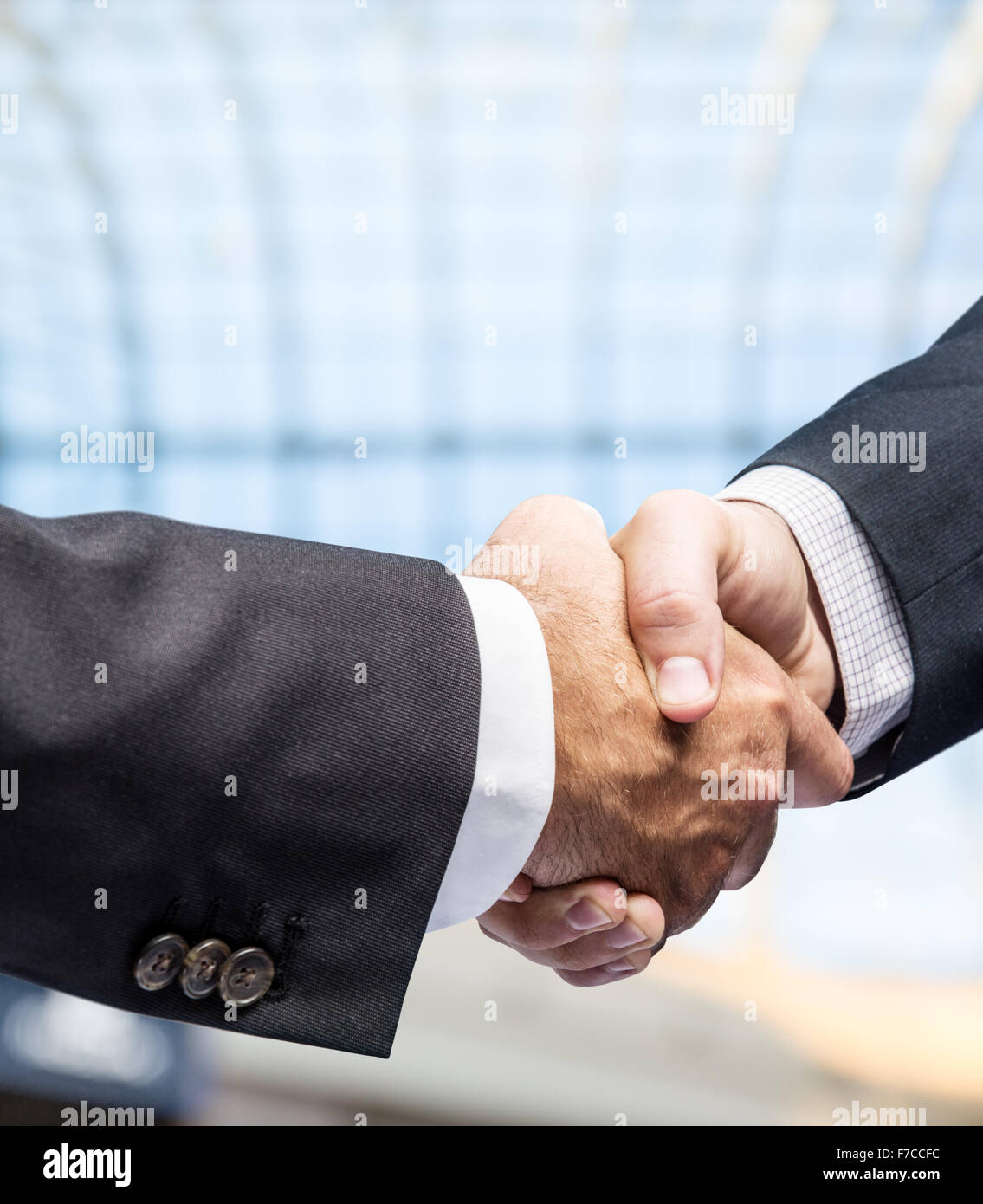 Stretta di mano. Closeup colpo di mani. Il centro business sullo sfondo. Foto Stock