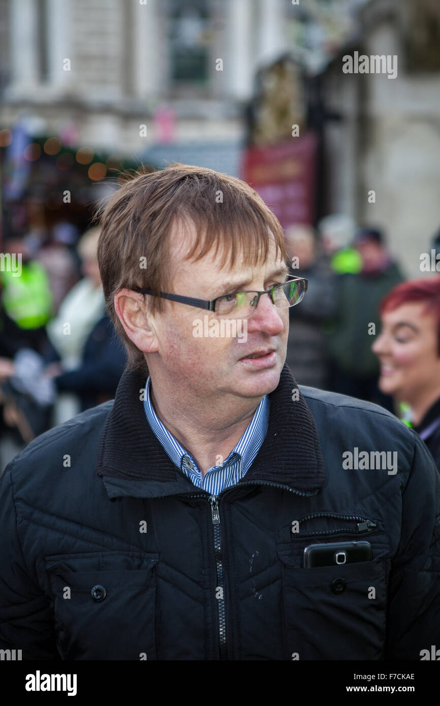 Belfast, Regno Unito. 28 Novembre, 2015. Willie Frazer fondatore e leader di un gruppo di pressione che le famiglie che agiscono per parenti innocenti (FAIR). Tenendo un popolo fedele la bandiera di protesta al terzo anniversario della città di Belfast al Consiglio di limitare i battenti la bandiera dell'Unione a 18 giorni per anno Credito: Bonzo Alamy/Live News Foto Stock