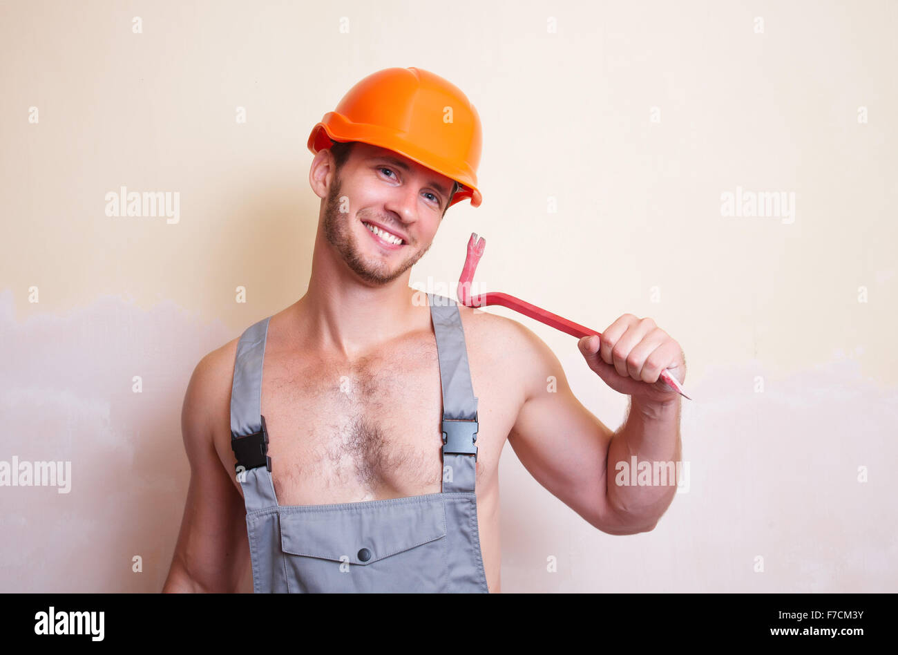 Un uomo in tuta e casco con un utensile per lo smontaggio Foto Stock