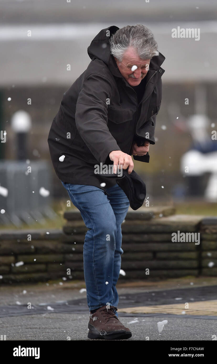 Un uomo quasi perde il suo cappello durante i venti forti causati dalla tempesta Clodagh a Porthcawl lungomare, South Wales, Regno Unito. Foto Stock