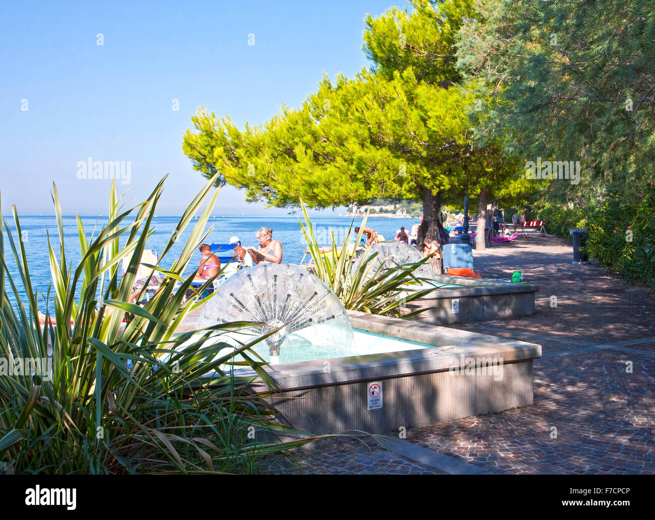 Trieste, Italia, bella vista estiva di Barcola promenade e libera la balneazione strand con fontane e lussureggiante vegetazione Foto Stock