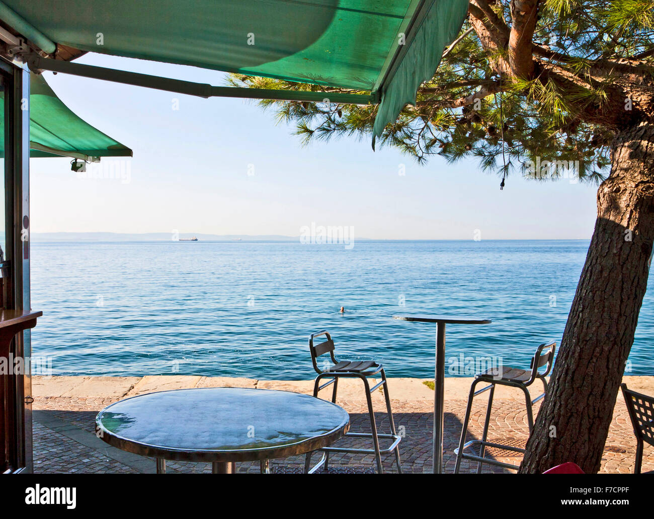 Trieste, Italia - caffè bar con tavoli e sedie in ombra a Barcola libera strand e passeggiata a mare Foto Stock