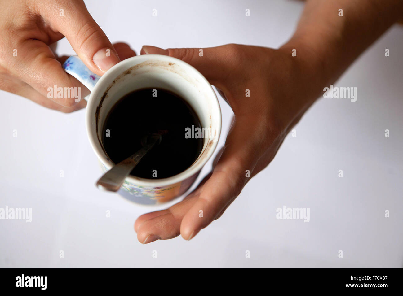 Una tazza di caffè nero al mattino in mani femminili. Tazza da sopra Foto Stock