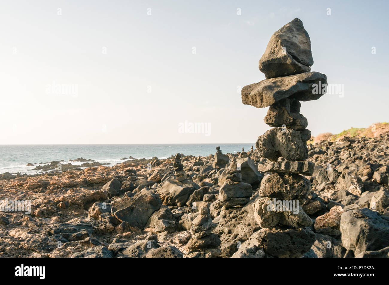 Rocce impilate su di un roccioso Spagnolo Spiaggia Foto Stock