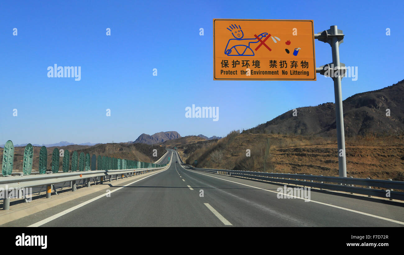 Il cinese cartello stradale: tutelare l'ambiente non littering. Autostrada G45 Daguang Expressway intitolata a nord verso la Grande Muraglia. Foto Stock