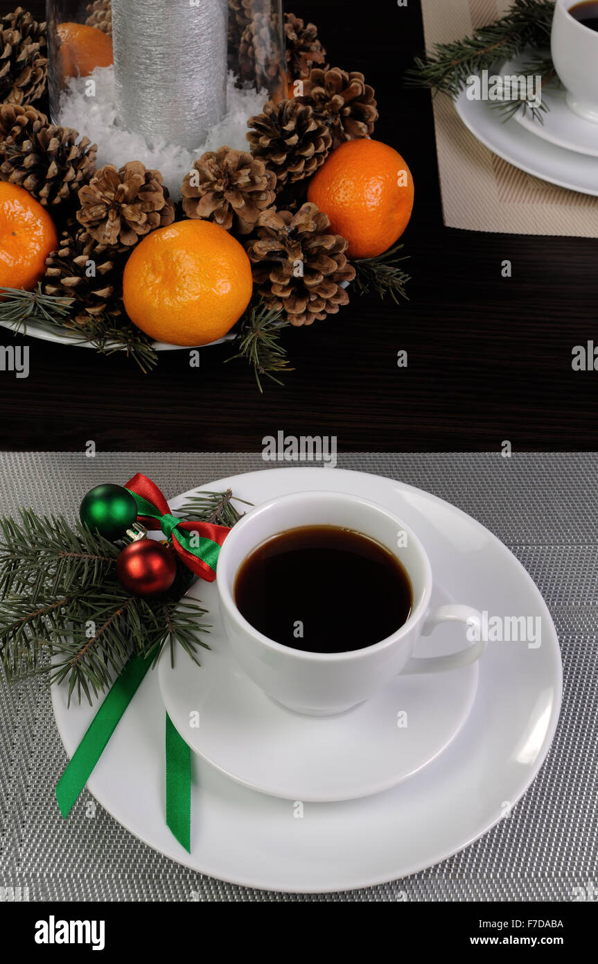 Tazza di caffè con rami di abete su un piattino sulla tavola del Natale Foto Stock