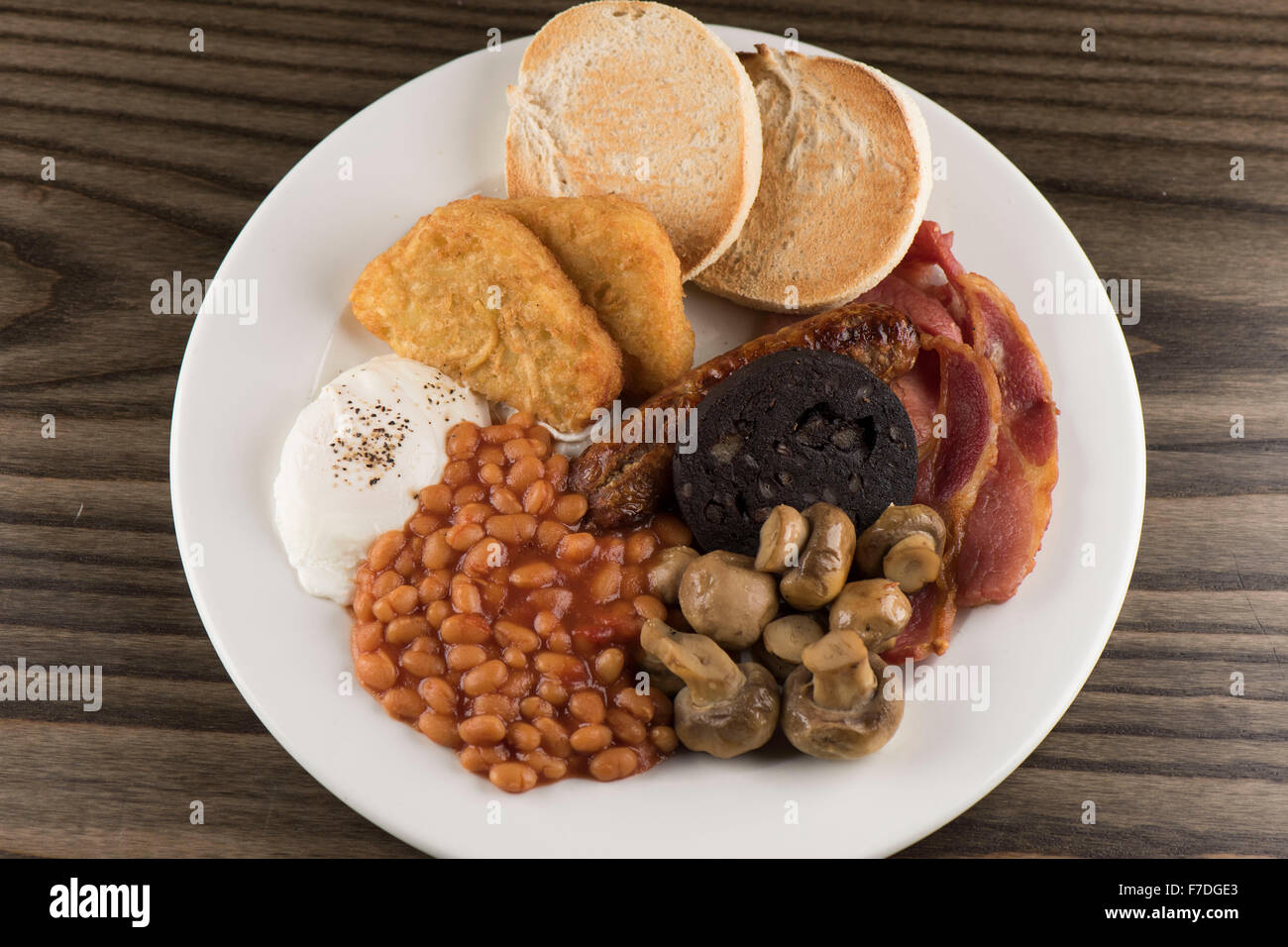 Un tradizionale inglese Domenica colazione consistente di fagioli, funghi, salsiccia, budino nero, muffin inglesi uova e bacon. Foto Stock