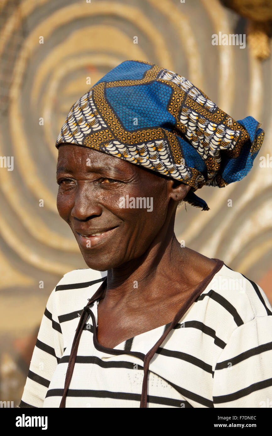 Nankani donna in composto di casa decorata con figure geometriche e disegni di animali, Sirigu, Ghana Foto Stock