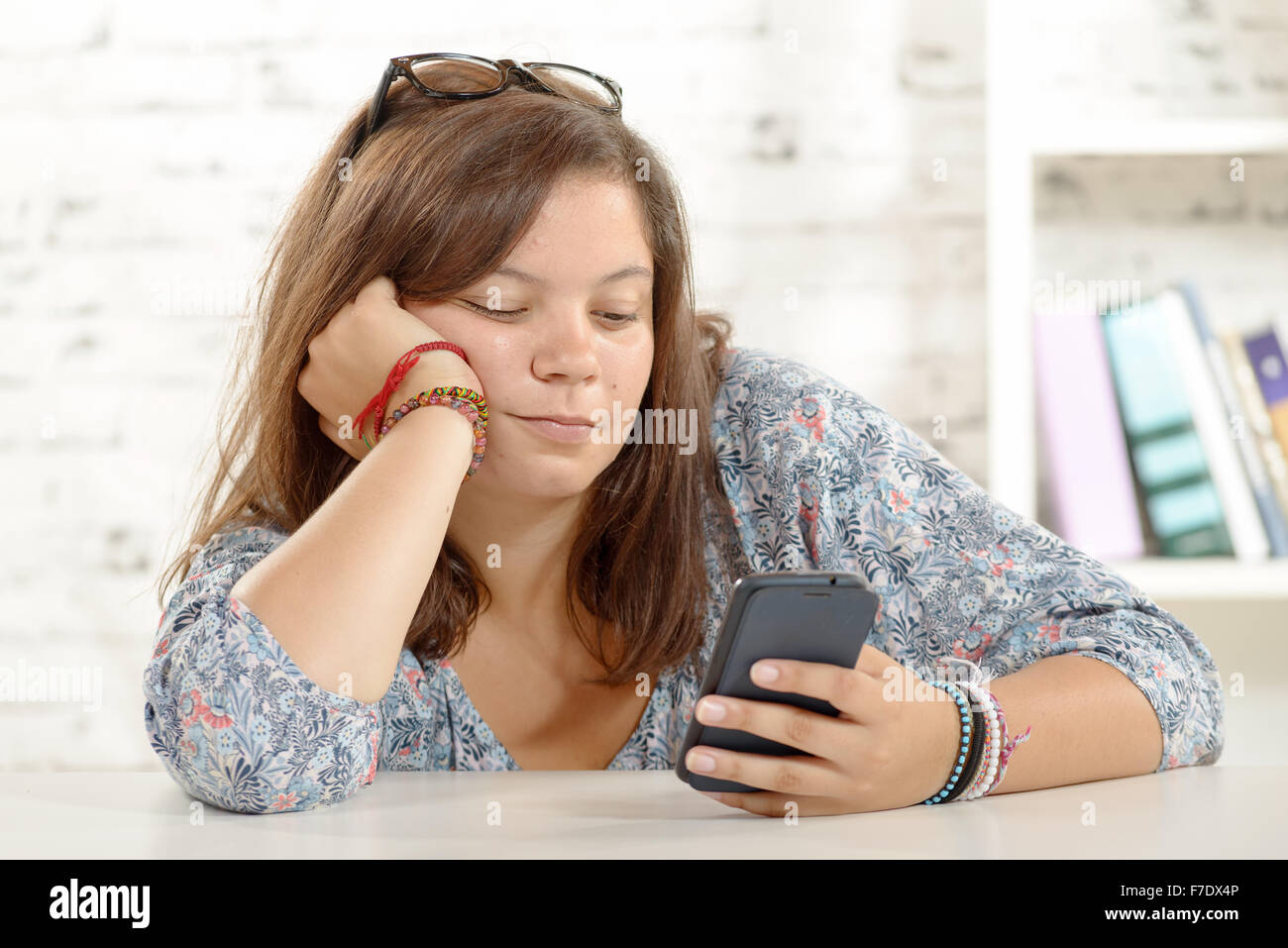 Una ragazza adolescente giocando con il suo telefono Foto Stock