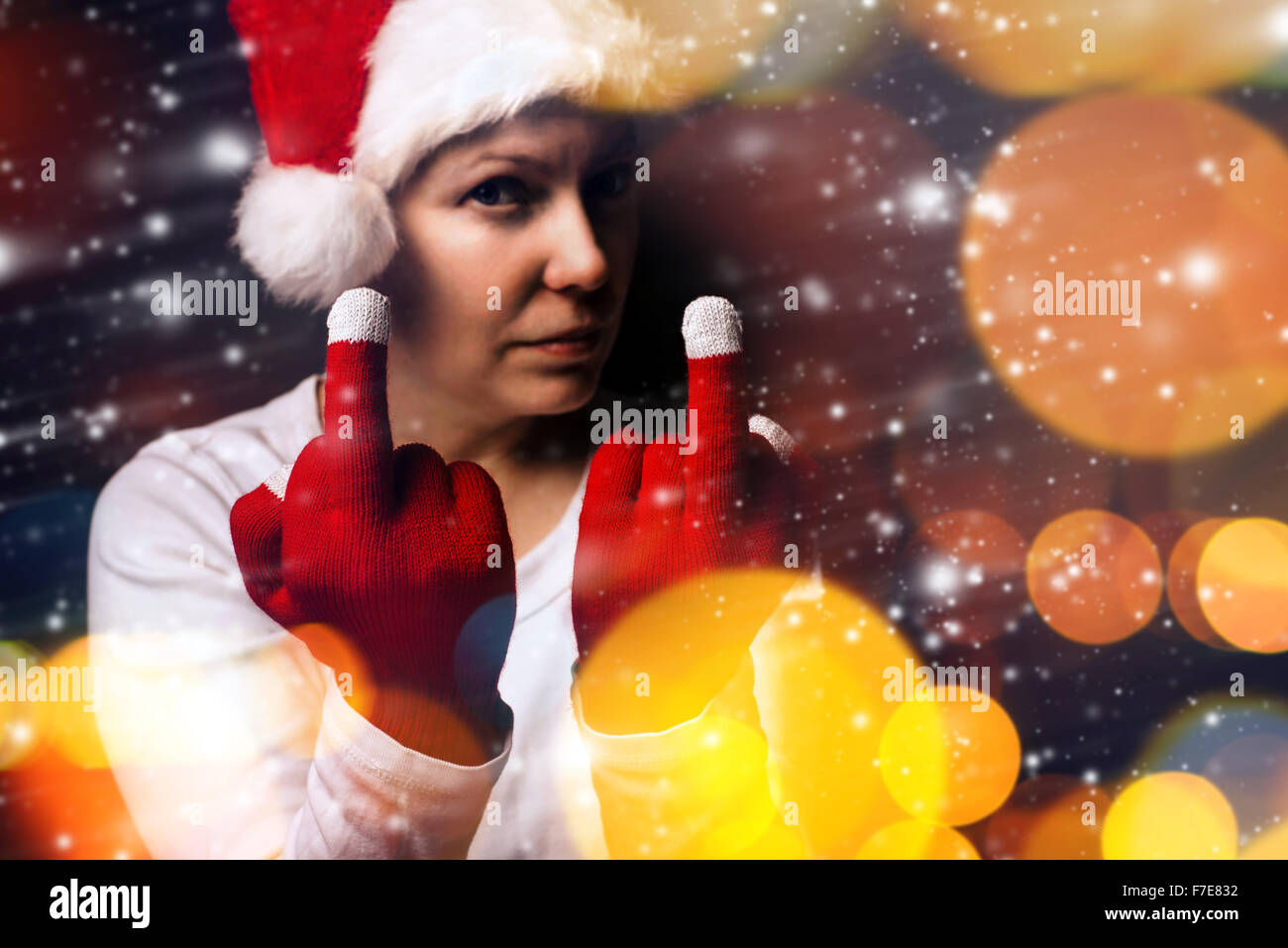 Regalo di natale è la fine di quest'anno, giovane donna adulta in Santa Claus costume che mostra il dito medio, il fuoco selettivo. Foto Stock