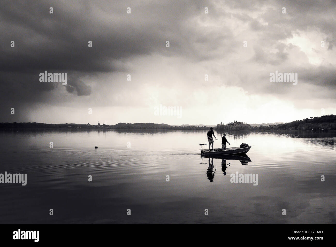 Due ragazzi la pesca su una piccola barca nel lago di Pusiano, Italia Foto Stock