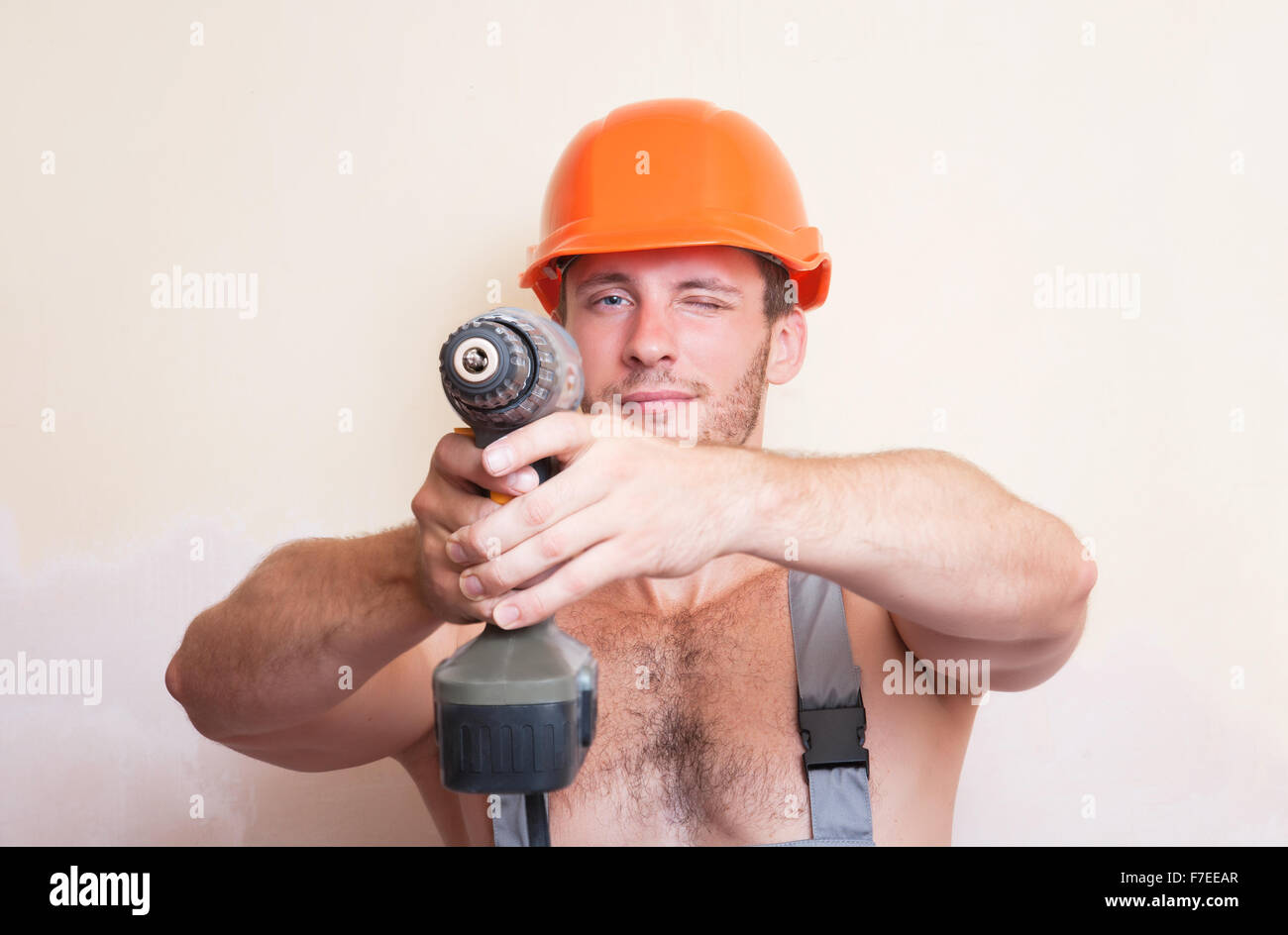 Un uomo in tuta e casco tenendo un cacciavite nei due bracci Foto Stock