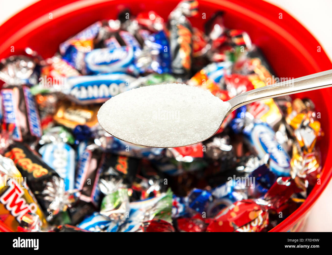 Un cucchiaio di zucchero con una selezione di cioccolatini da una lattina di celebrazioni. Foto Stock