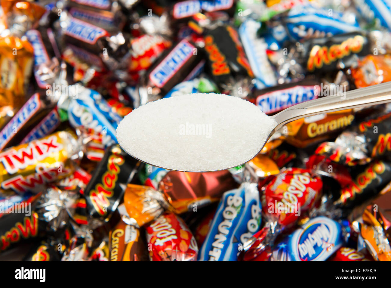 Un cucchiaio di zucchero con una selezione di cioccolatini da una lattina di celebrazioni. Foto Stock