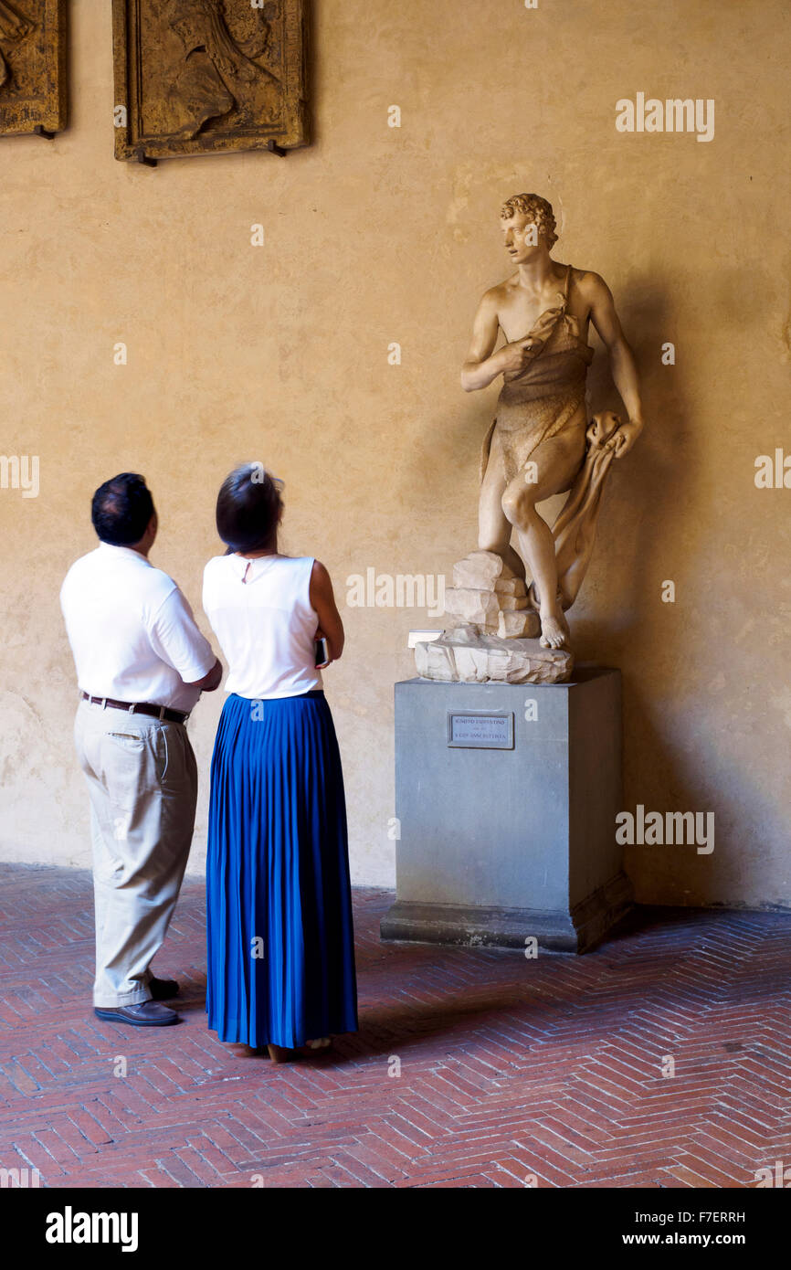 I turisti a guardare a S. Giovanni Battista statua da ignoti nel Museo Nazionale del Bargello - Firenze, Italia Foto Stock