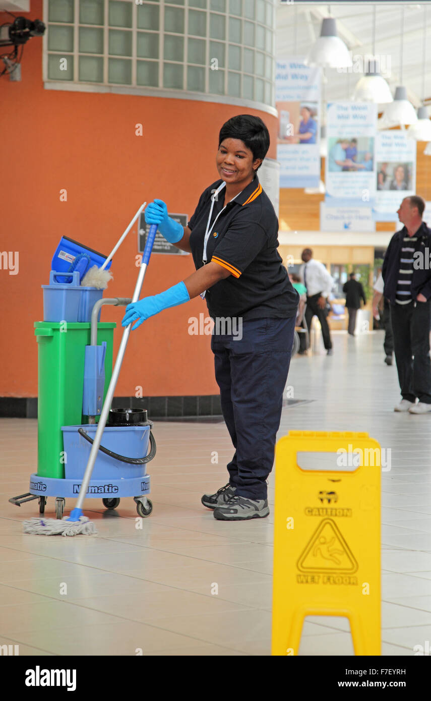 Un ospedale cleaner mops il pavimento in un moderno ospedale del Regno Unito Foto Stock