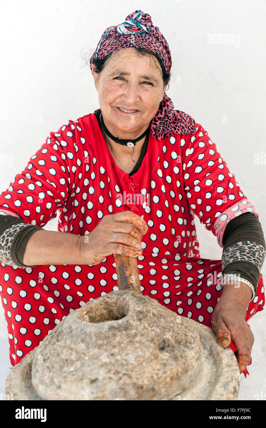 Donna marocchina premendo i dadi di argan per olio. Foto Stock