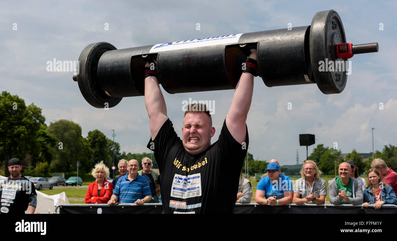 Un uomo forte dimostra la sua forza ad un pubblico di atletica leggera evento sportivo. Foto Stock