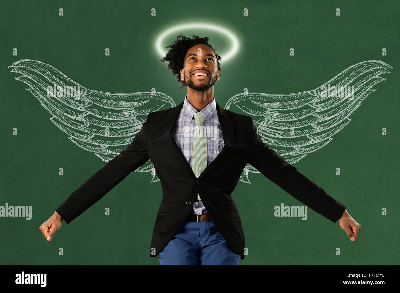 African American businessman hero con ali e alo sulla superficie verde Foto Stock