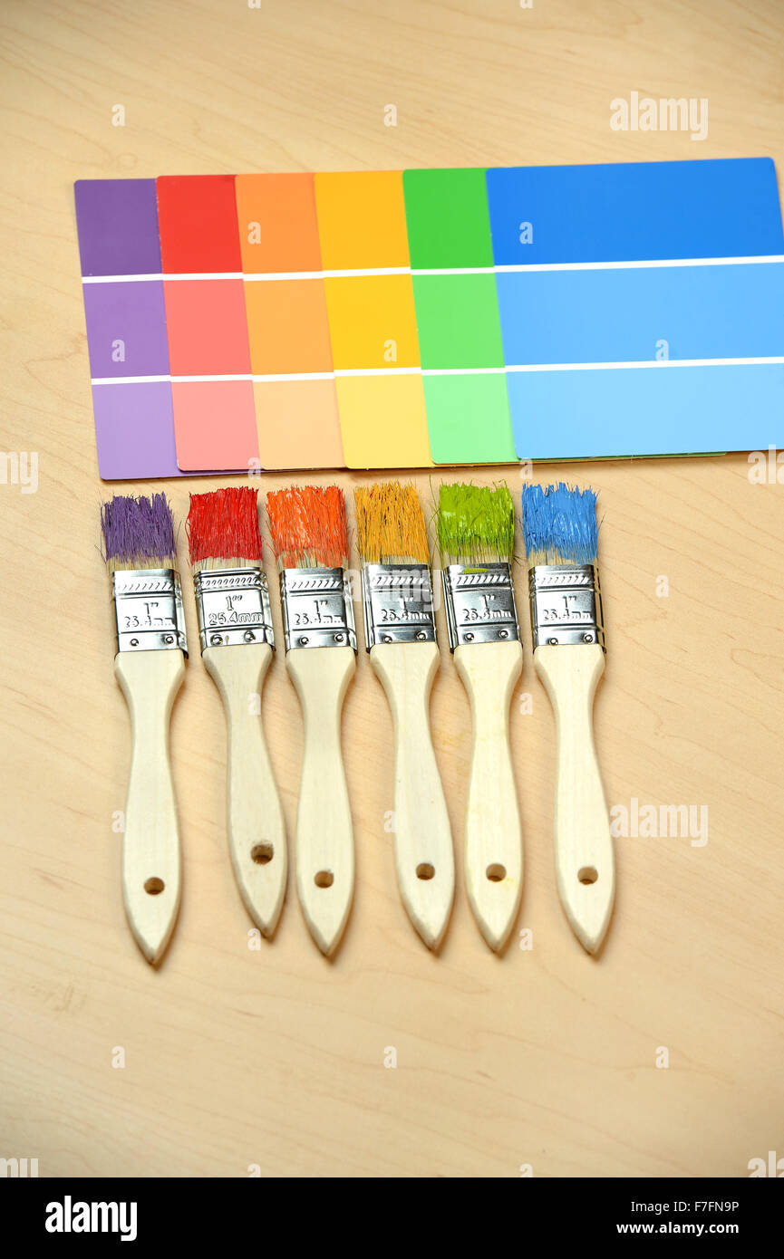 Pennelli con i campioni di colori su una superficie di legno Foto Stock