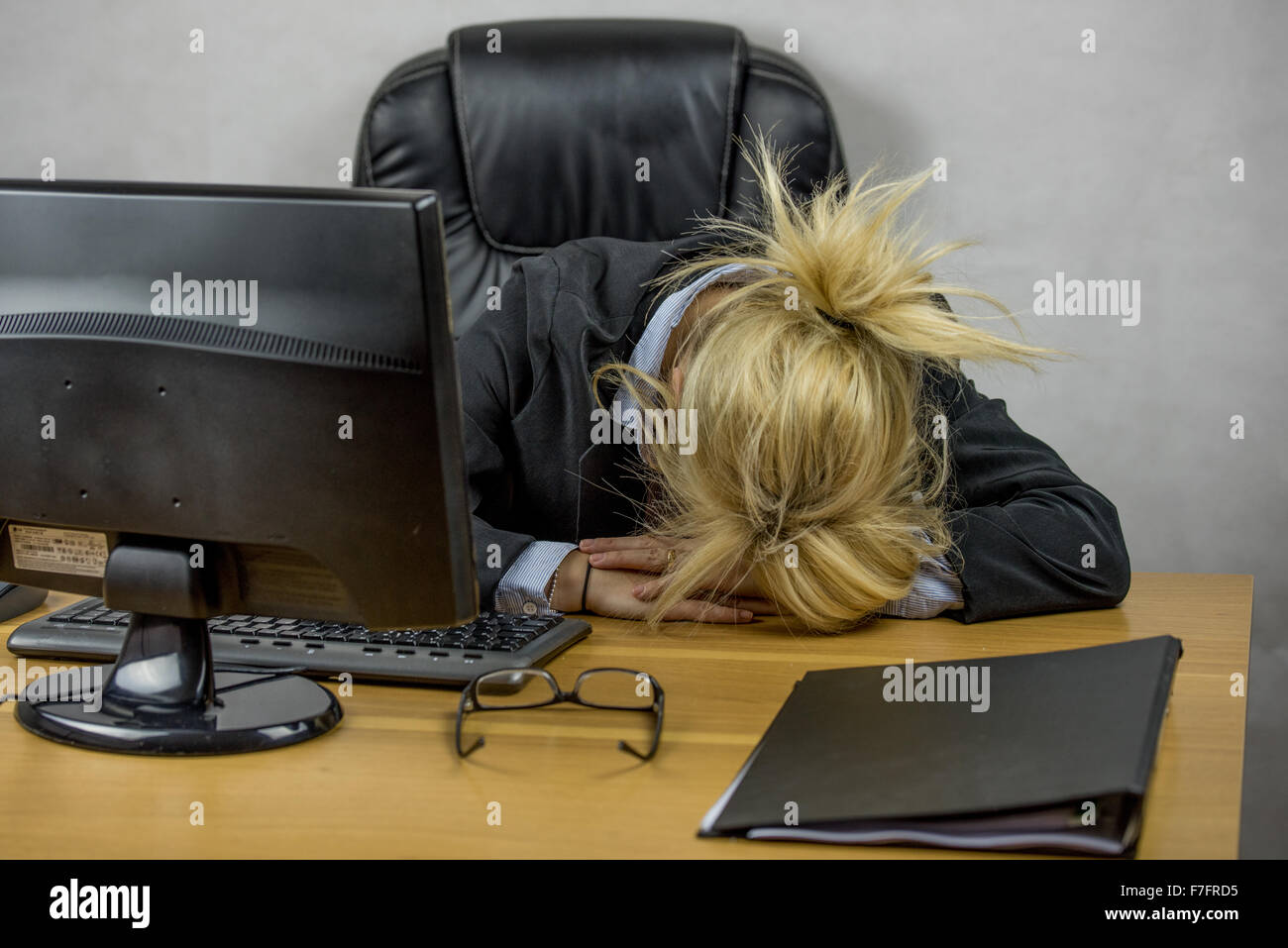 Una femmina di lavoratore di ufficio seduto alla sua scrivania su di lei da 9 a 5 job Foto Stock