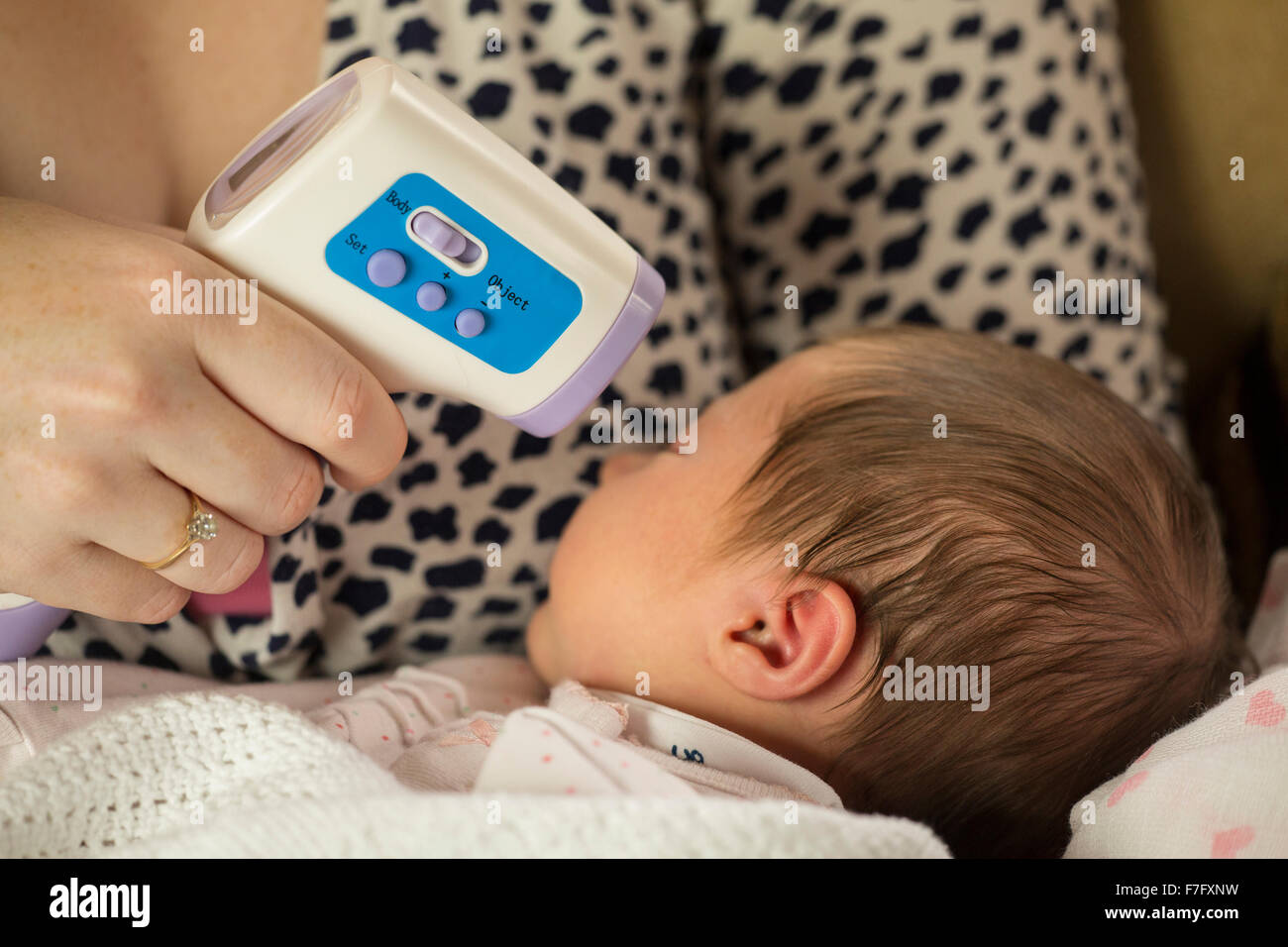 Mamma controllo neonato la temperatura con un termometro a