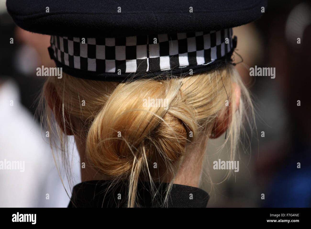 Una fotografia posteriore di una bionda Kent donna di polizia e qui legati i capelli fino alle sue spalle e nascosto nel suo cappello di polizia Foto Stock