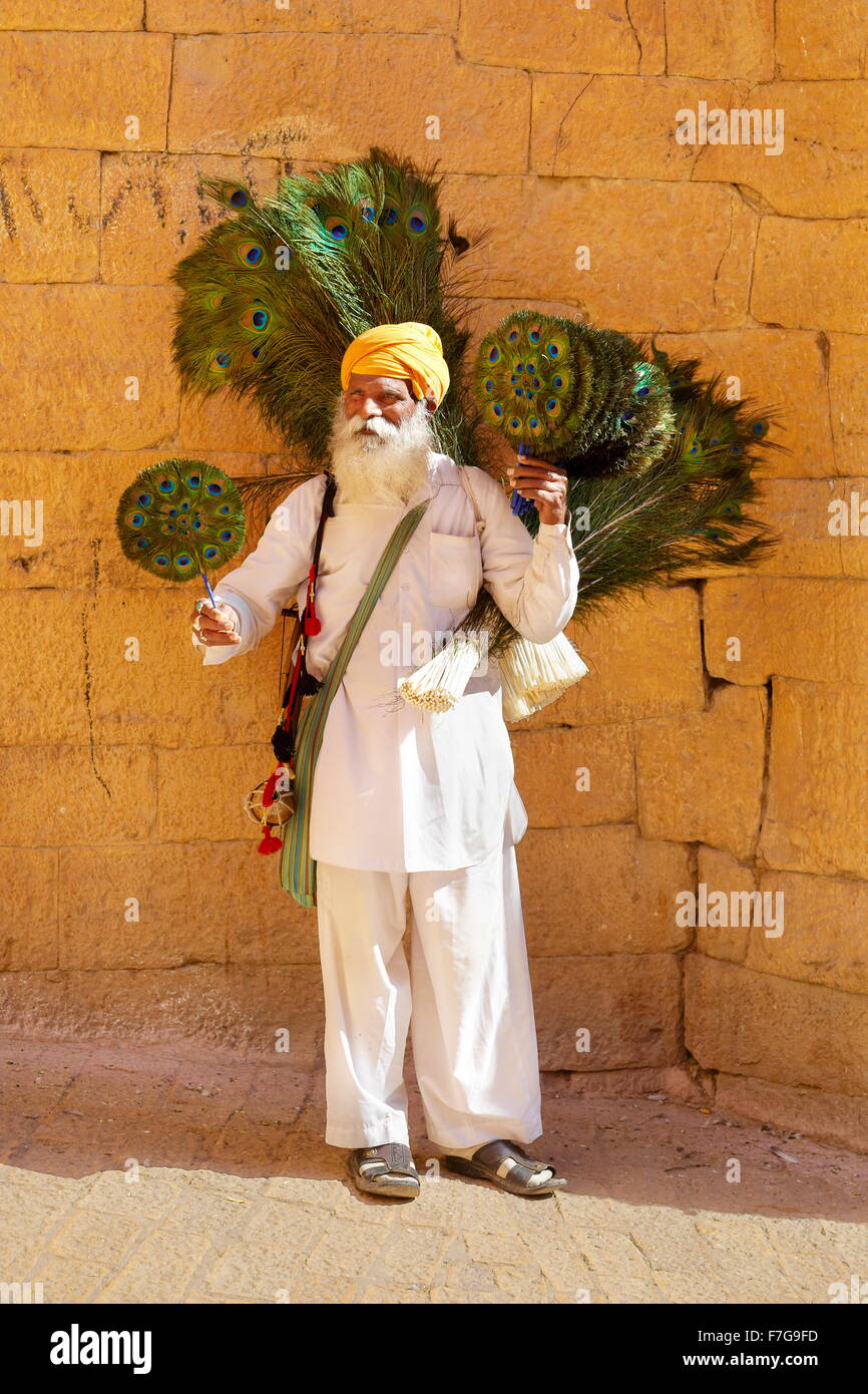 Scena di strada con india uomo con turbante vendere peacock feather ventole, Jaisalmer Fort, Rajasthan, India Foto Stock