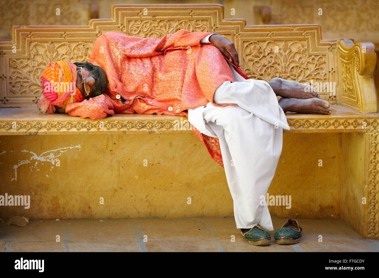 Scena di strada con india uomo che indossa tutban dorme sul sedile, Jaisalmer, stato del Rajasthan, India Foto Stock