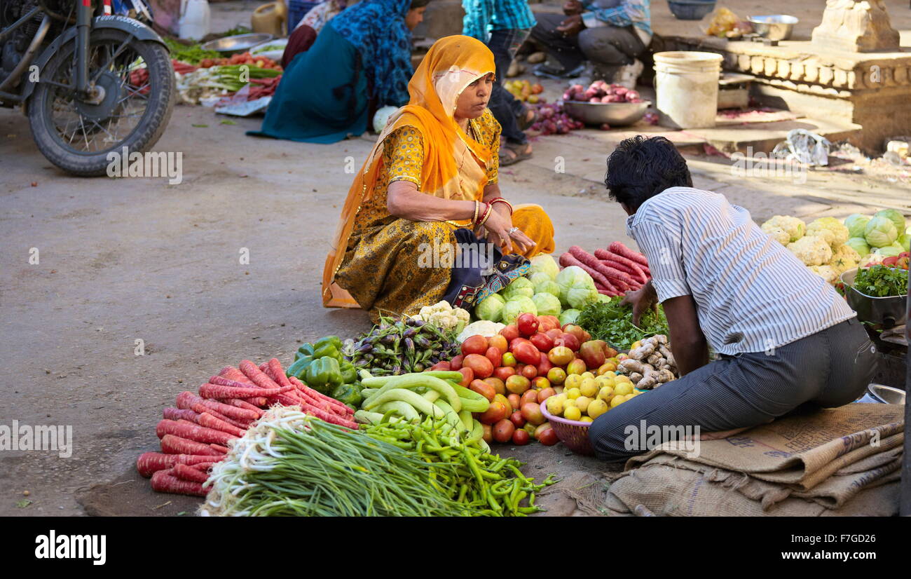 Scena di strada con india donna indù in sari verdure di vendita sul mercato, Jaisalmer, India Foto Stock