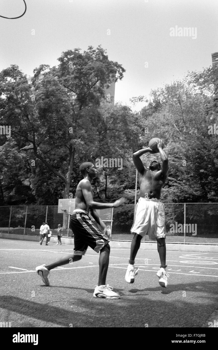 NEW YORK CITY - 22 giugno: due ragazzi nero gioca in uno Harlem pallacanestro, Catena-collegamento recinto scatole, visto il 22 giugno 2008 in Foto Stock