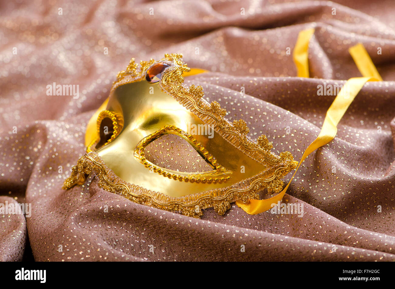 Maschera d'oro su sfondo satinato Foto Stock