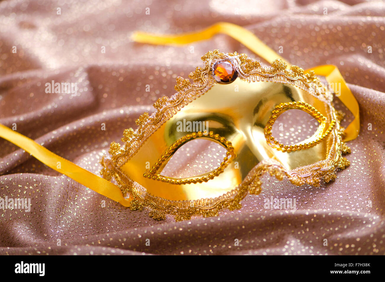 Maschera d'oro su sfondo satinato Foto Stock