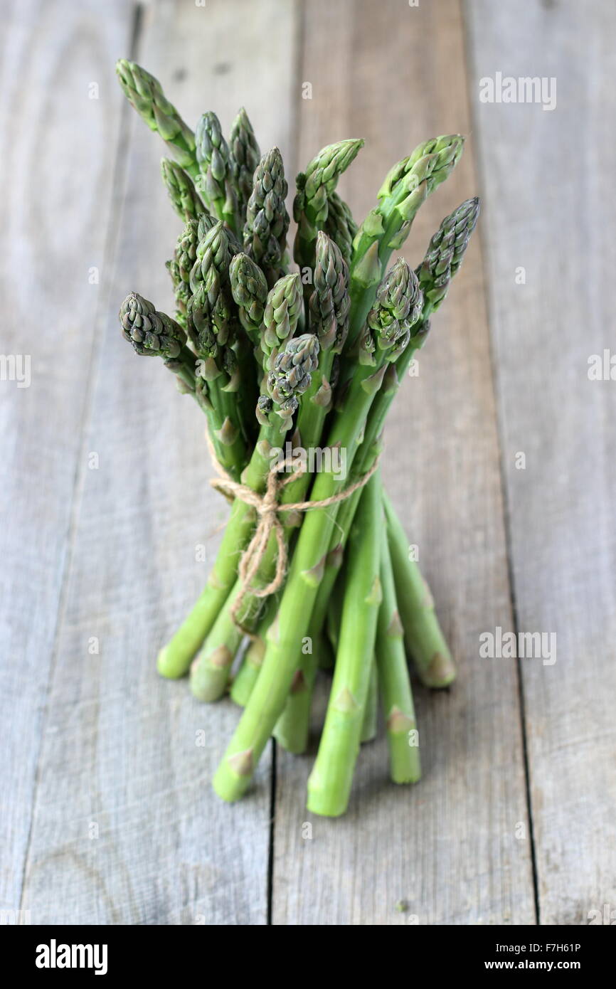 Un mazzetto di asparagi su una tavola di legno Foto Stock