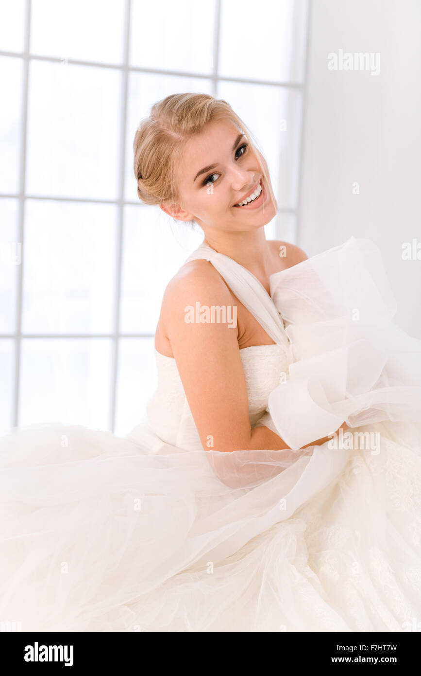 Ritratto di una sposa felice in piedi in bianco abito da sposa e guardando la fotocamera Foto Stock