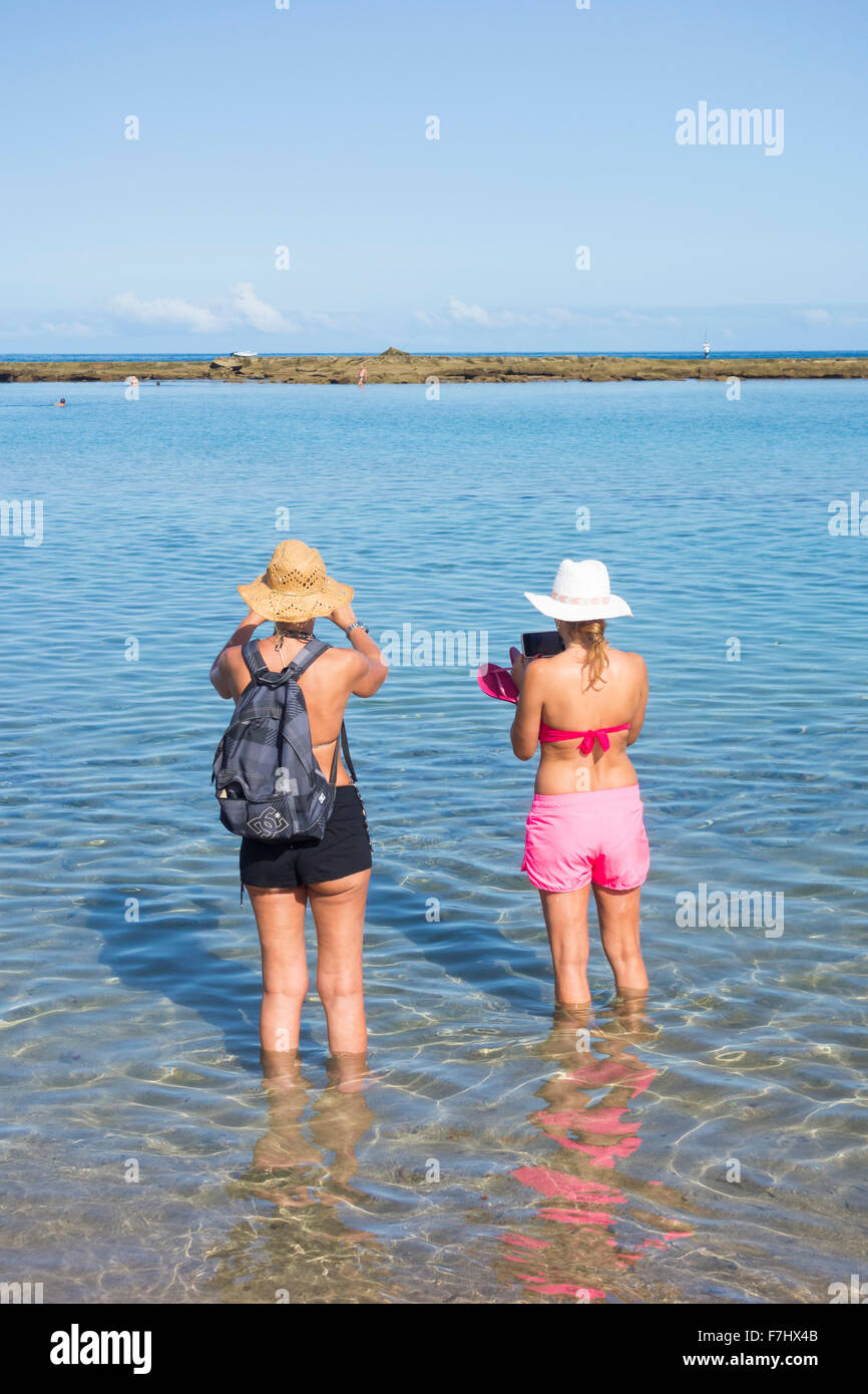 Due giovani turisti femmina tenendo selfies sulla spiaggia Foto Stock