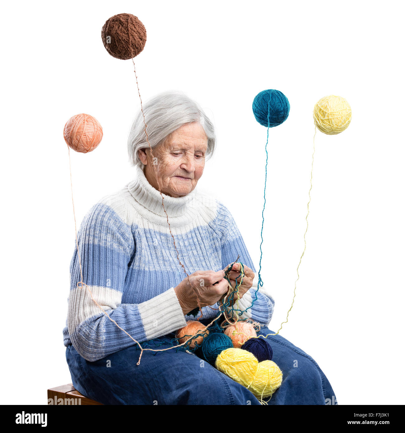 Senior Maglieria donna su sfondo bianco, palline di lana intorno battenti, donna mago Foto Stock