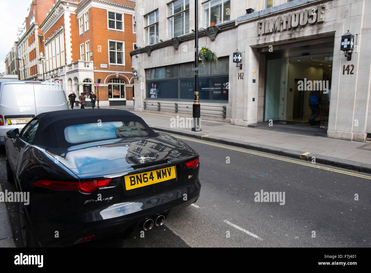 Jaguar F-type automobile parcheggiata di fronte film house con poster per spettro nella finestra in Wardour Street, Soho, London, England, Regno Unito Foto Stock