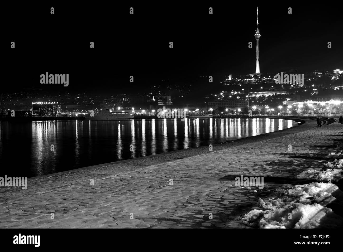 Baku Bulvar con la neve di notte, guardando verso la torre di telecomunicazioni, nella capitale dell'Azerbaigian, in bianco e nero Foto Stock