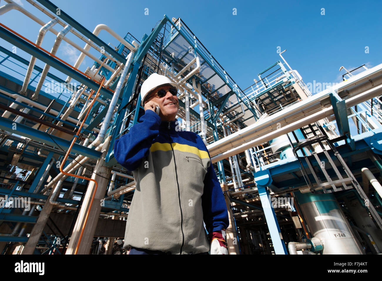 Il petrolio e il gas lavoratore con tubazioni di raffineria Foto Stock