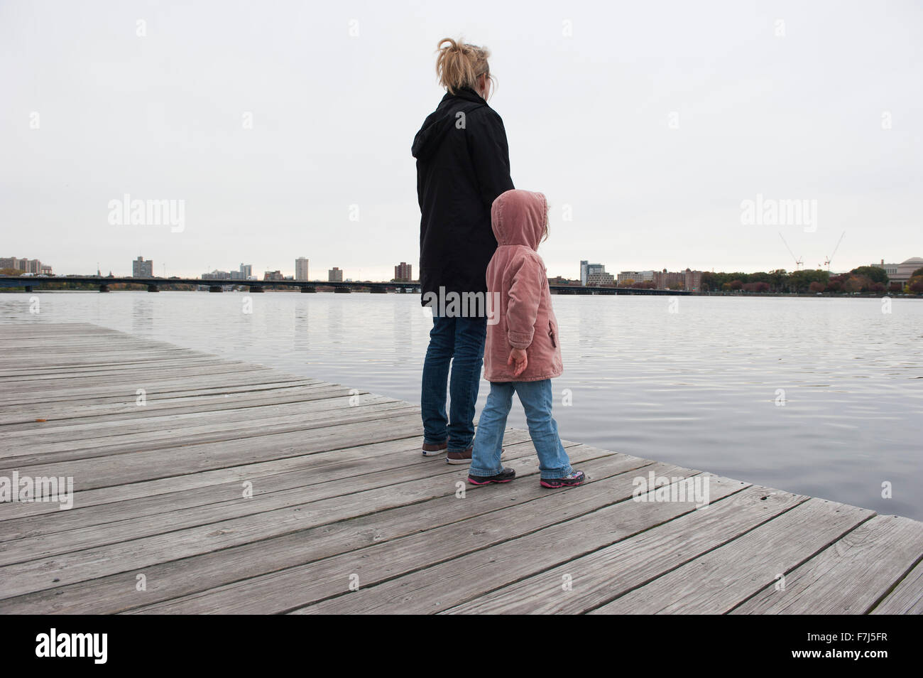 Madre e figlia insieme in piedi sul dock, guardando l'acqua Foto Stock