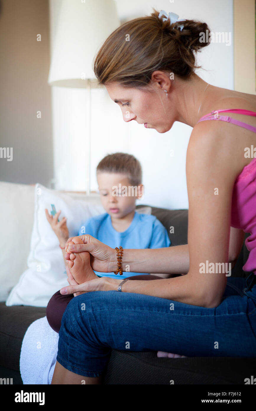 Reportage su riflessologia plantare per i bambini. Il reflexologist si occupa di bambini dai 5 anni in poi verso l'alto. La riflessologia agisce sulla loro concentrazione, memoria, equilibrio e serenità e dormire. 5 anno vecchio ragazzo in una sessione. Foto Stock