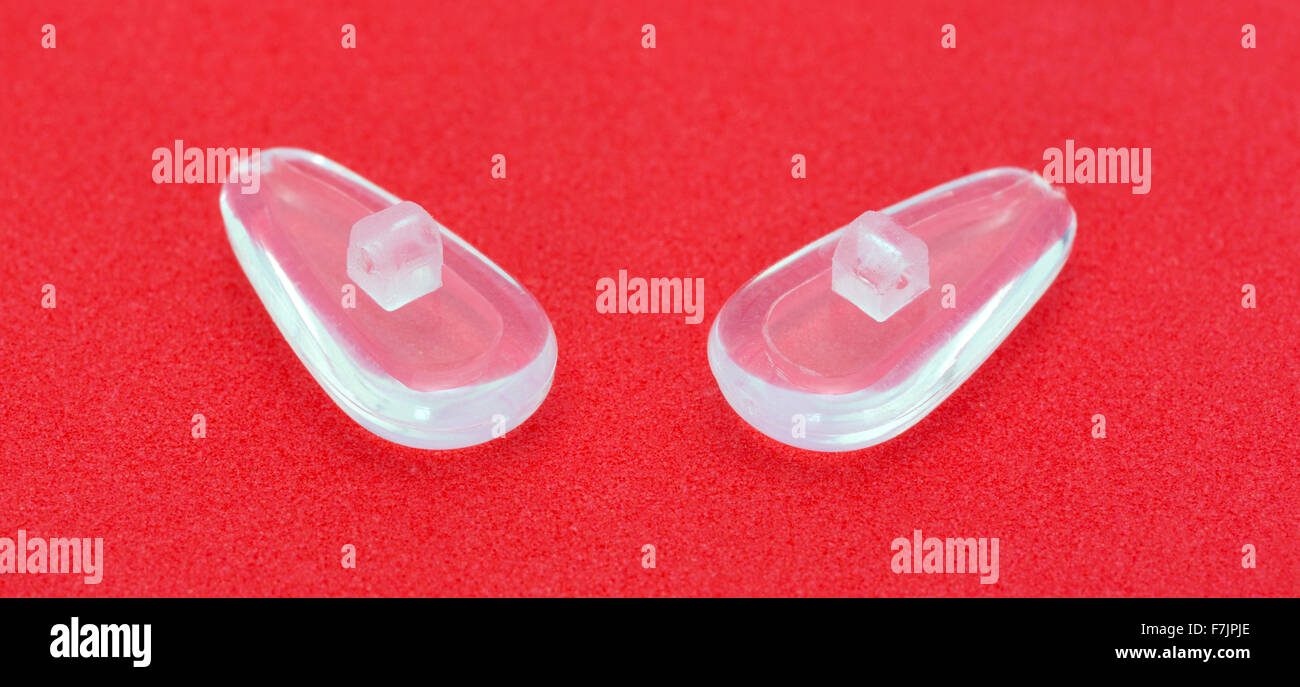 Una coppia di nuove vite in ipoallergenico nasello di silicone su un brillante sfondo rosso. Foto Stock