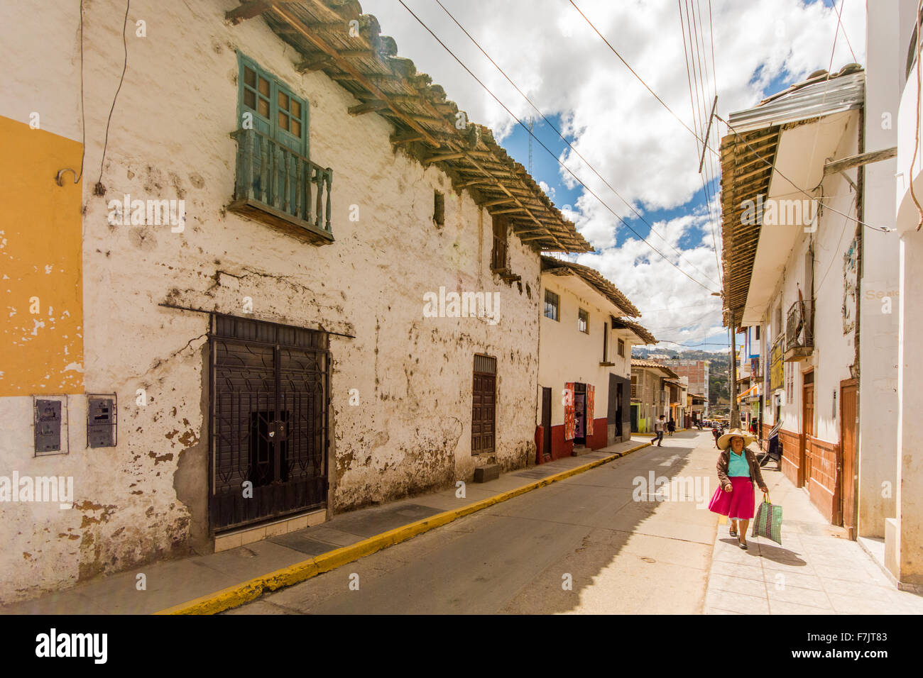 Tradizionalmente vestiti Donna Peruviana passeggiate attraverso la vecchia strada coloniale della città di Cajabamba Cajamarca nella regione del Perù Foto Stock