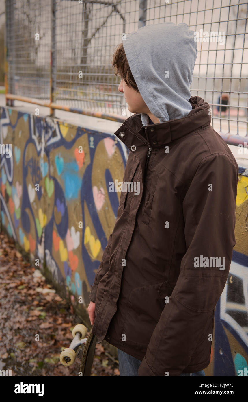 Ragazzo adolescente che indossa una felpa con cappuccio in piedi in uno  skateboard park Foto stock - Alamy