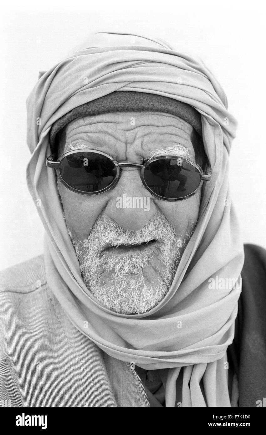 Un close up ritratto di un anziano uomo tunisino indossando occhiali da sole. Tozeur, Tunisia, Nord Africa. Foto Stock