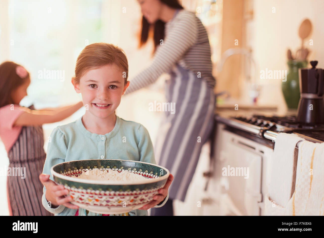Ritratto sorridente ragazza cottura vaschetta di contenimento di farina in cucina Foto Stock