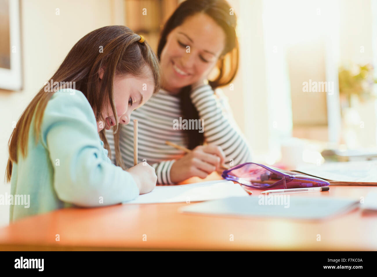 Madre guarda la figlia fare i compiti Foto Stock