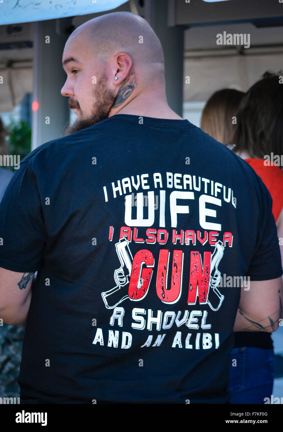 Tatuato uomo che indossa offensivo tee shirt minacciando chiunque che ambisce alla sua moglie con una pistola, un shove, & un alibi assiste Trump rally in FL Foto Stock